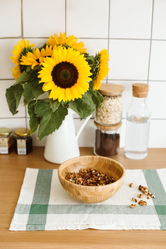 Elegant kitchen setup with sunflowers and nuts on a wooden surface.